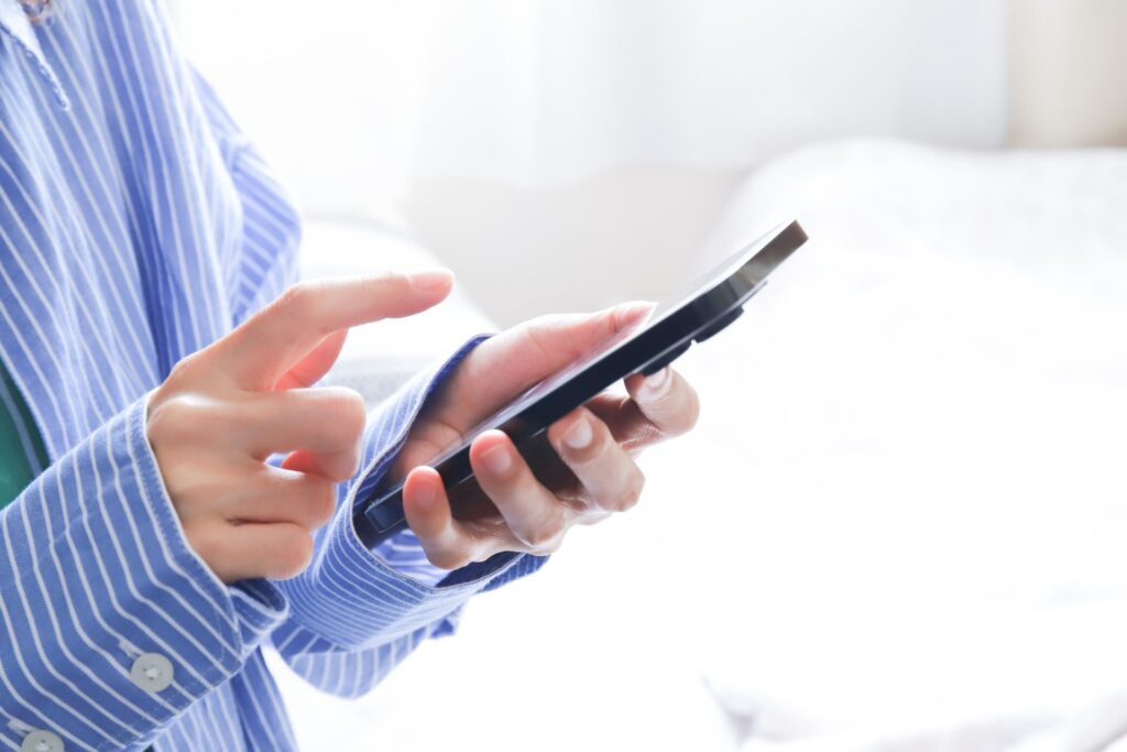 飲食店ホームページでメニューを確認しながらスマートフォンで予約操作をしている手元の写真