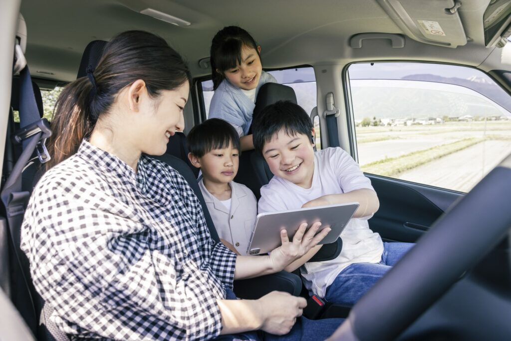目的地をタブレットで調べる家族