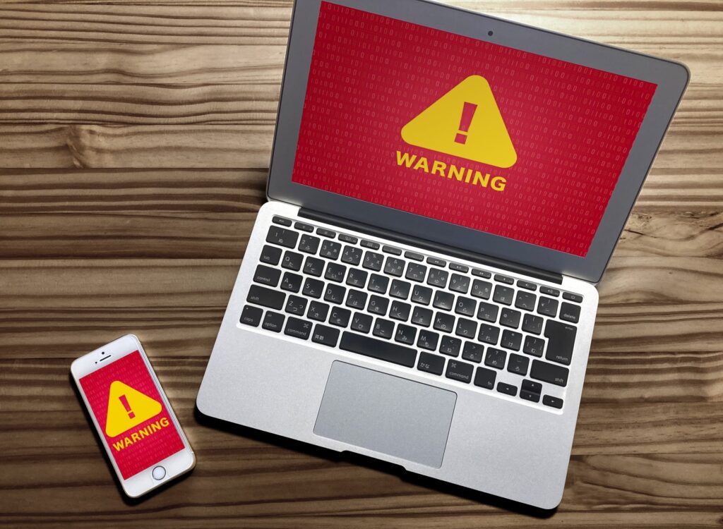 パソコンとスマホの画面に「WRNING」と警告が出ている様子